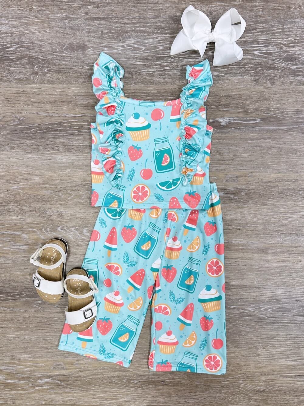 Stylish baby girl summer trousers. Baby girls trendy pants in small flower  print on colored wooden background. Kids fashion outfit on sale Stock Photo  - Alamy